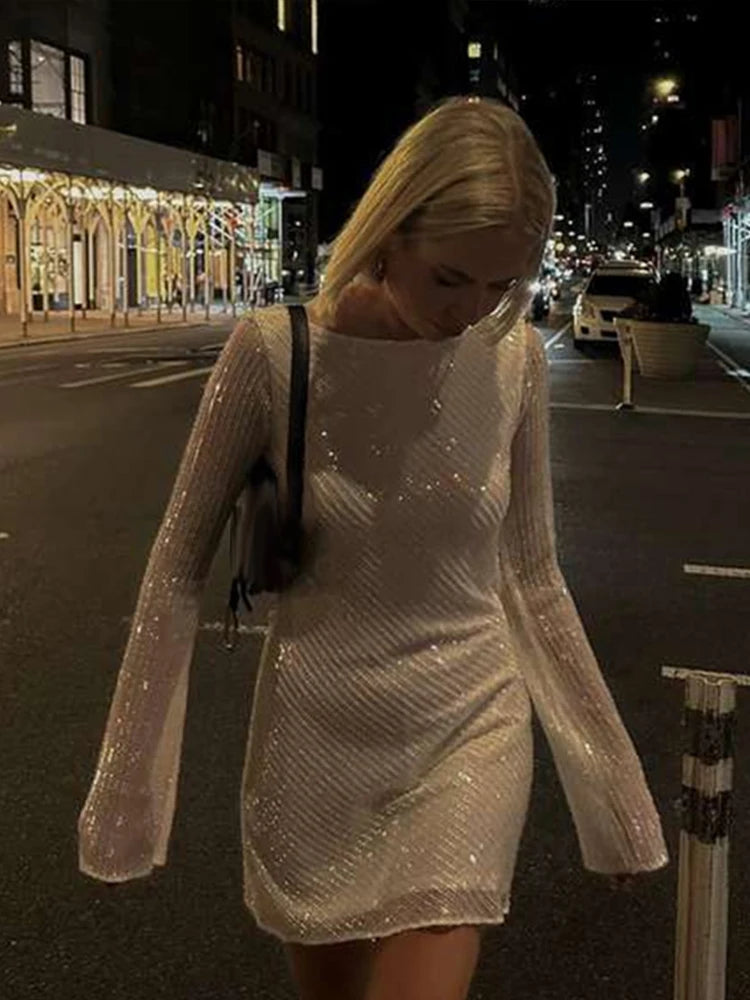 Robe courte à sequins : dos nu et manches évasées pour un look de soirée scintillant.