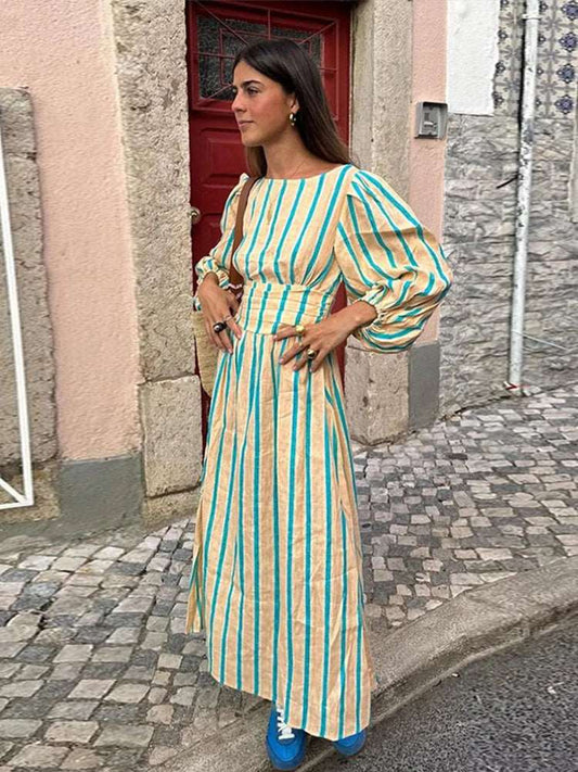 Découvrez notre robe longue d'été, ornée d'un imprimé rayé sophistiqué. Avec son encolure élégante en O, ses manches lanternes délicates et son design dos nu, cette robe taille haute allie confort et style pour un look estival raffiné.