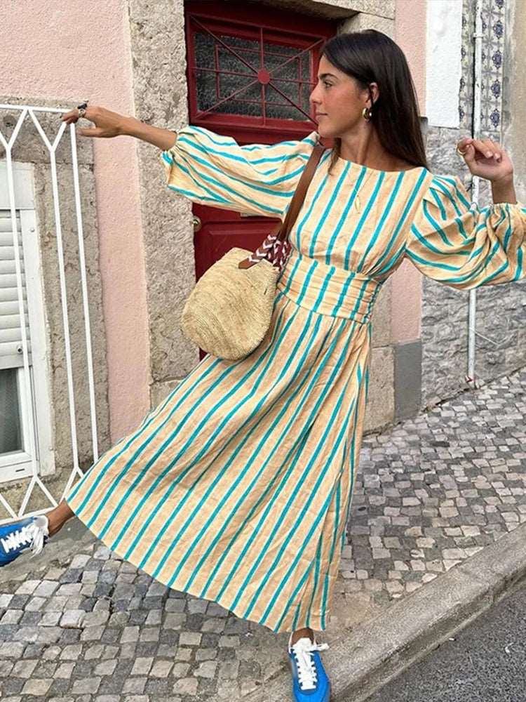 Découvrez notre robe longue d'été, ornée d'un imprimé rayé sophistiqué. Avec son encolure élégante en O, ses manches lanternes délicates et son design dos nu, cette robe taille haute allie confort et style pour un look estival raffiné.