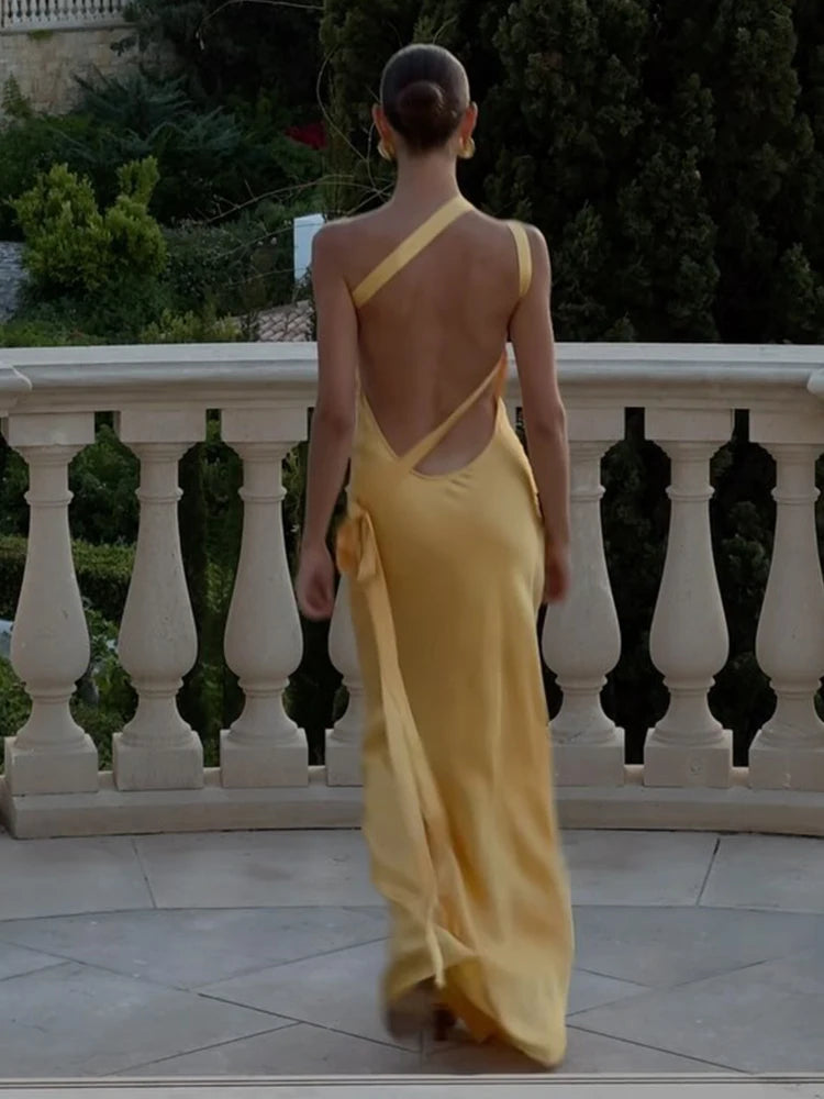 Cette robe est parfaite pour les soirées d'été. Son dos nu et ses lacets subliment votre silhouette, tandis que son décolleté irrégulier ajoute une touche moderne. Faites tourner les têtes avec cette pièce incontournable !