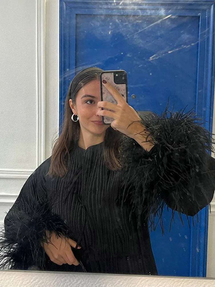 Adoptez un look audacieux avec notre veste noire ornée de plumes, coupe oversize et détails lacés, pour un style chic et tendance.