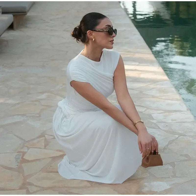 Découvrez notre robe blanche plissée irrégulière, un must-have de l'été. Avec son encolure ronde, sans manches et coupe ajustée, cette robe incarne le chic moderne. Idéale pour une allure sophistiquée. NEITH