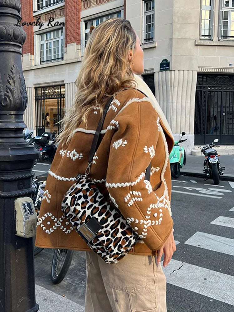 Enveloppez-vous de douceur avec notre manteau en laine d'agneau brodé, coupe décontractée et col en V, pour un look cosy et élégant cet automne-hiver.