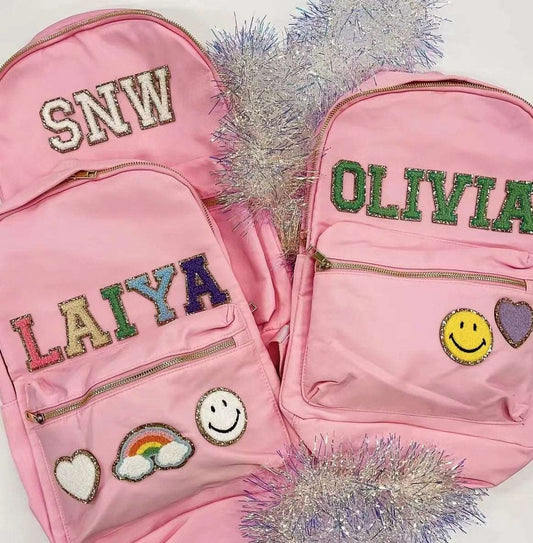 Préparez vos enfants pour la rentrée scolaire avec ce sac à dos en nylon, décoré de lettres en chenille que vous pouvez personnaliser. Conçu pour résister aux aventures quotidiennes tout en ajoutant une touche personnelle à leur look.