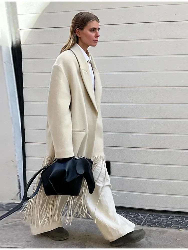 Élevez votre style avec notre manteau écru à franges, élégant et doté de poches, parfait pour un look raffiné et moderne cet automne-hiver.