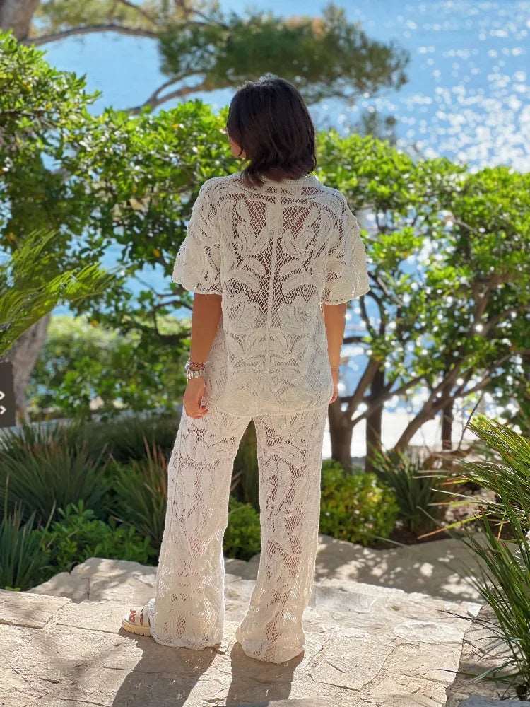 Adoptez un look élégant avec notre ensemble en crochet ajouré. Ce costume féminin comprend un haut à manches courtes à boutonnage simple et un pantalon à jambes larges. Parfait pour les vacances et les activités de loisirs.