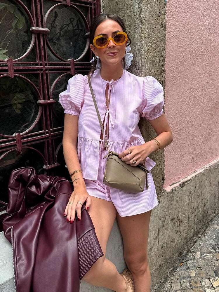 Découvrez notre ensemble chic rayé rose. Un haut plissé à manches courtes bouffantes et col rond avec lacets & short taille haute. Brillez avec style!